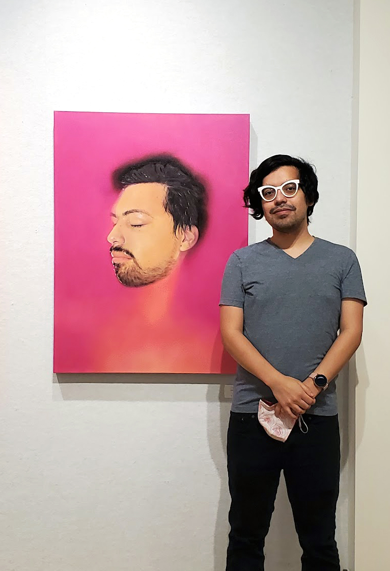 A photo of me posing with a painting my friend made.
